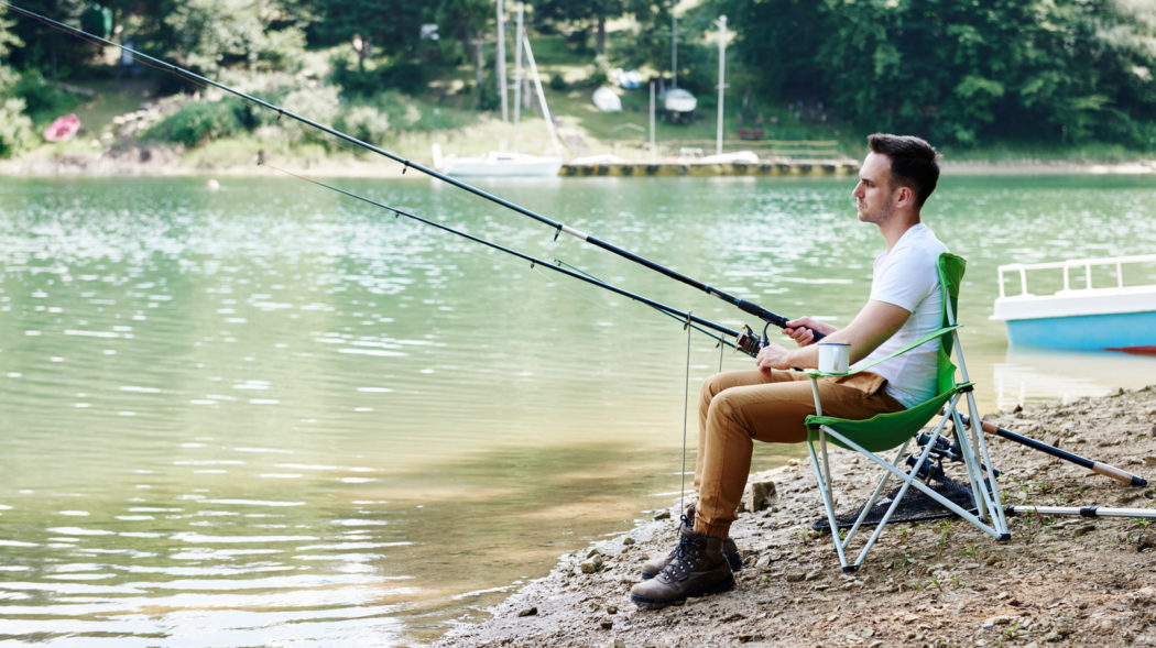 Men with telescoping fishing rod sitting on fishing chair