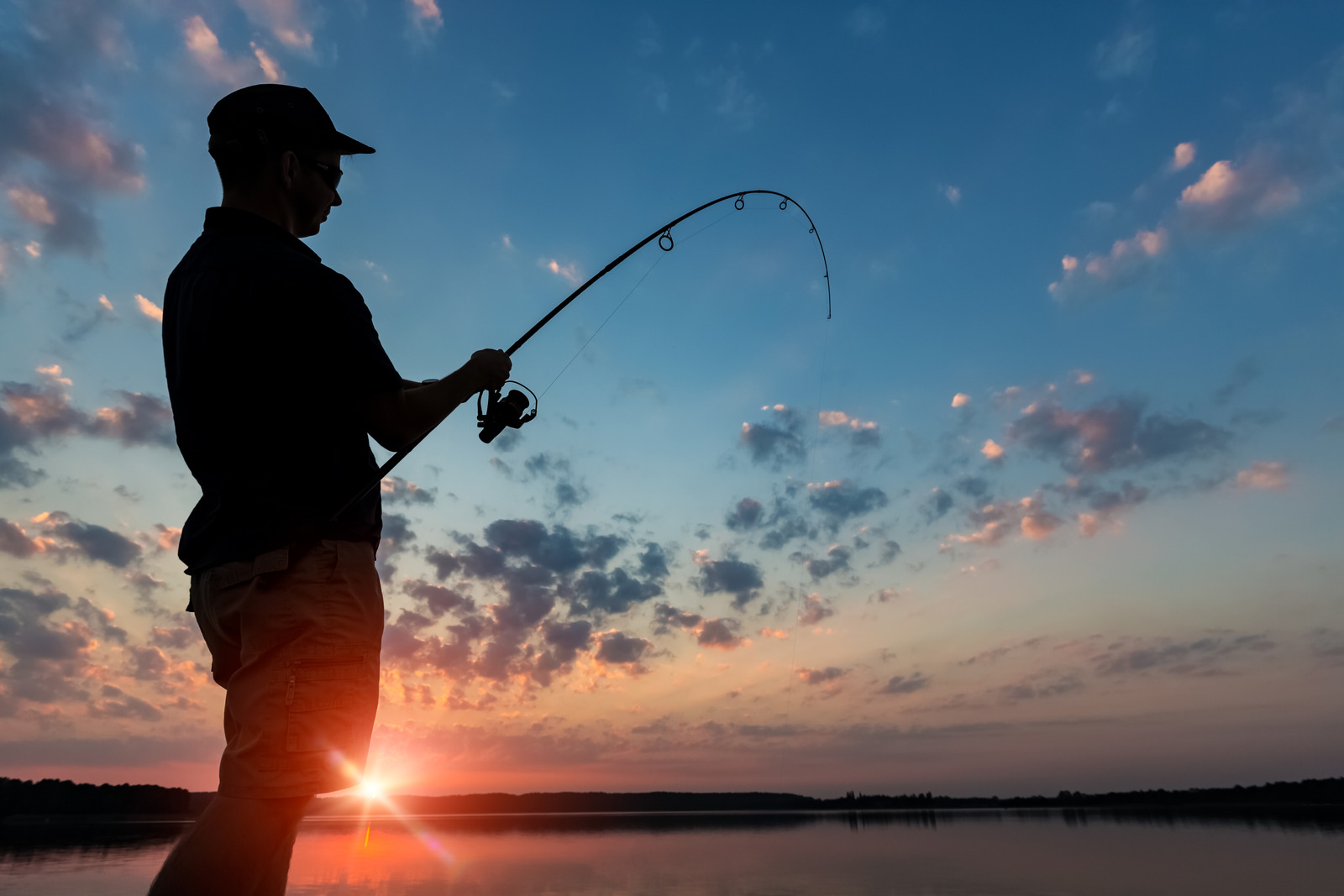 fishing rod lake fisherman men sport summer lure sunset water outdoor sunrise fish - stock image