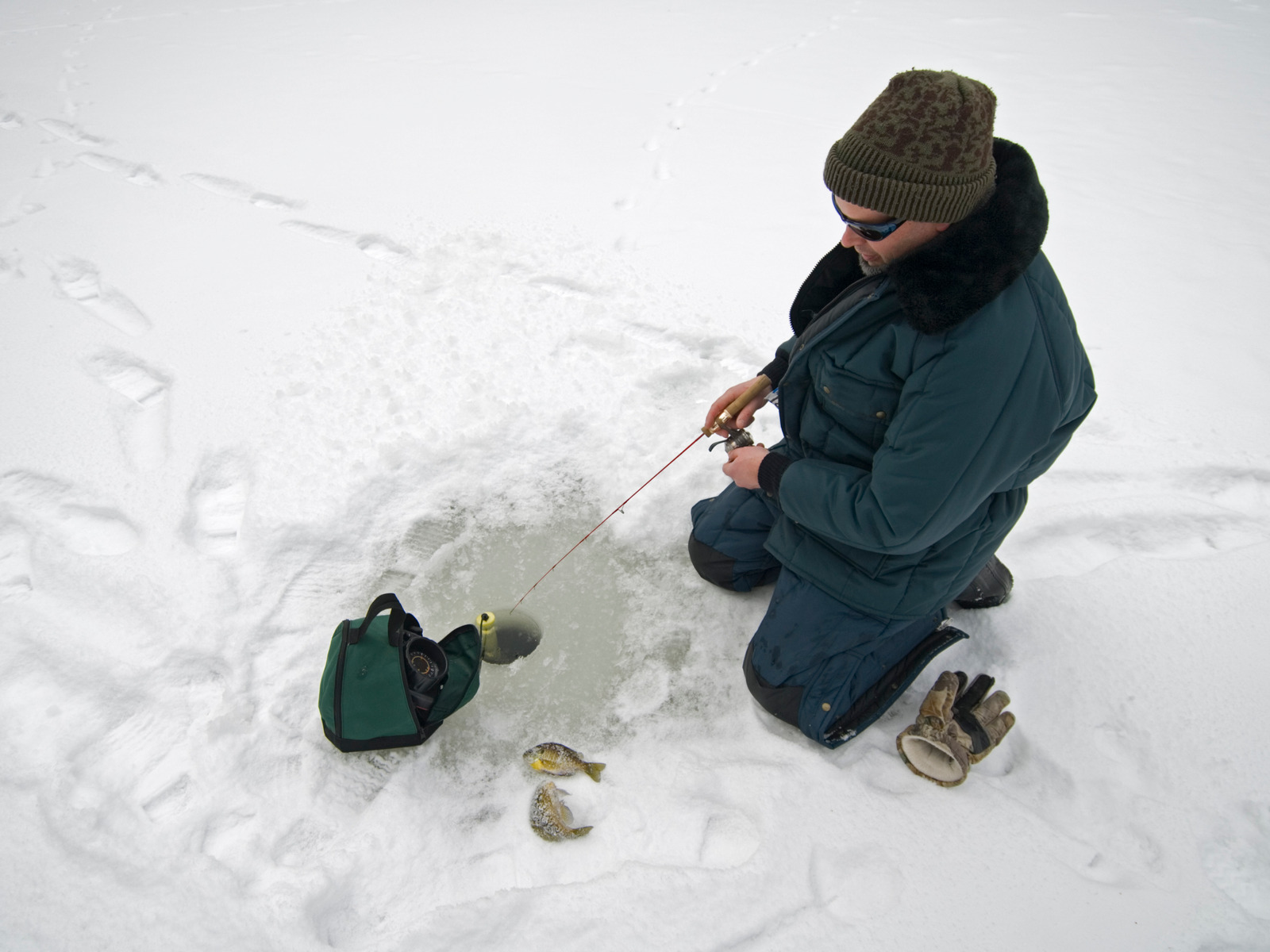 Ice fishing on a Michigan pond, an angler uses electronic fish finder to catch fish.