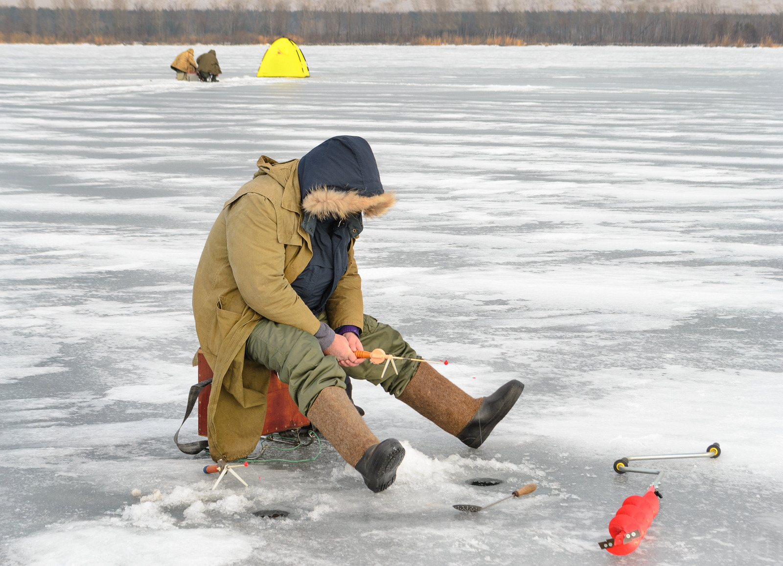 Fisherman catching a fish on the ice fishing